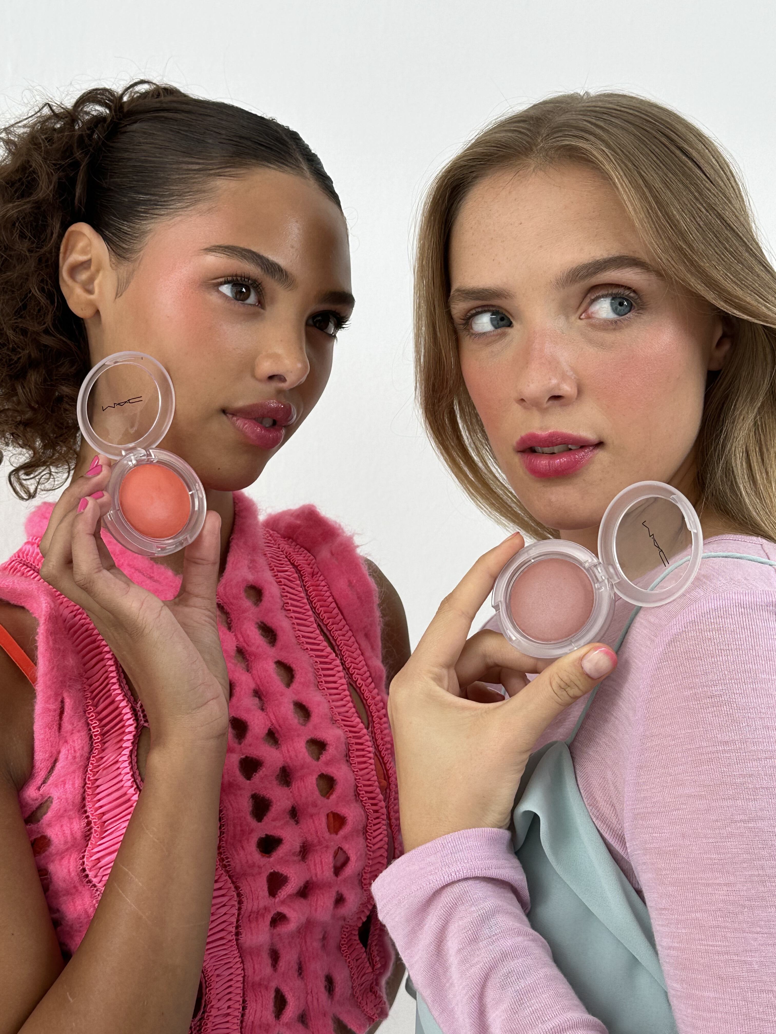 兩名女性，一人擁有捲曲的頭髮，另一人則是金色長髮，她們分別展示著 MAC 超漾光持色奶凍腮紅，表現出粉嫩光澤的妝效。